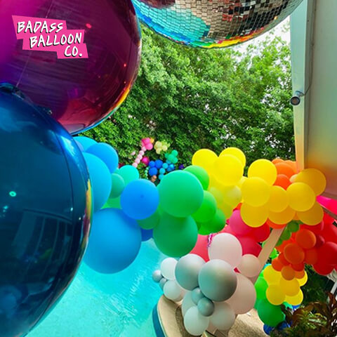 House decorated with a rainbow balloon garland. Balloons by Badass Balloon Co. 